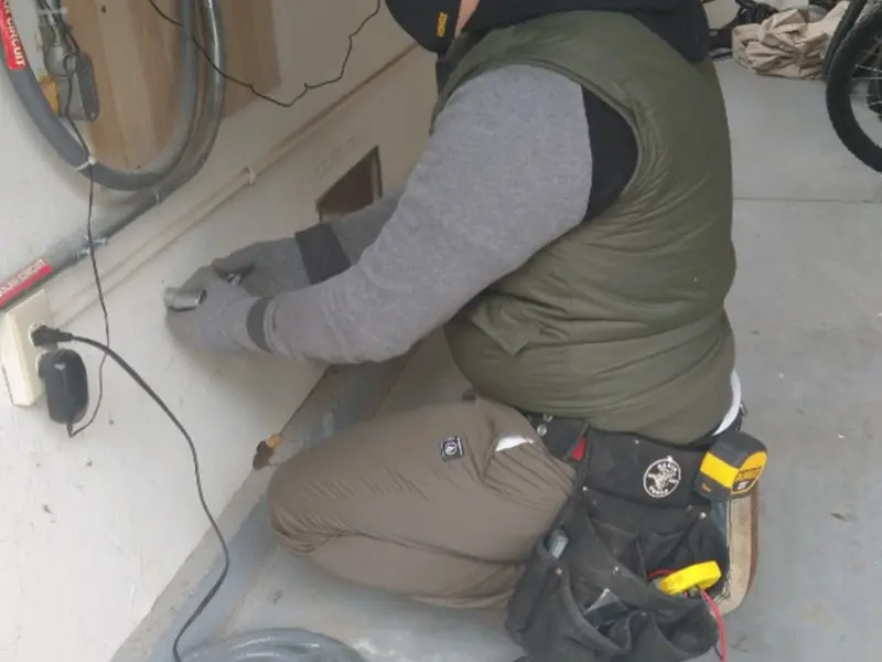 Electrician performing outlet wiring in a Amwell garage